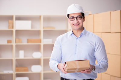 A postal worker in a storage room holding a package, representing postal service short-term disability.