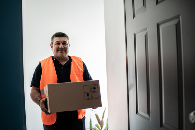 Postal worker delivering a package, highlighting Postal Disability Benefits.