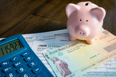 Piggy bank, calculator, and tax forms illustrating retirement savings strategies.