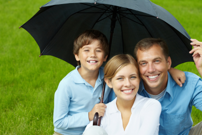 Happy family under an umbrella symbolizing financial security with supplemental life insurance.