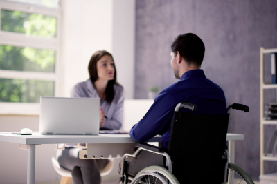 USPS employee in a wheelchair discusses light duty disability with a supervisor.