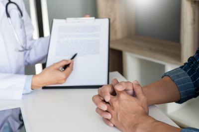 Doctor explaining disability paperwork to a postal worker.